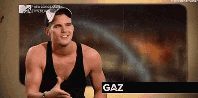 a shirtless man wearing a baseball cap and a tank top is talking to someone and the word gaz is on the screen .