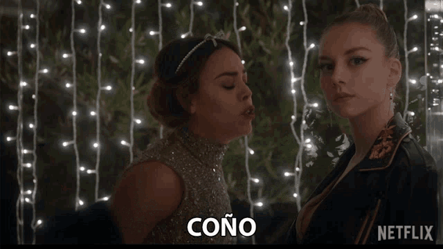 two women are standing next to each other and the word cono is on the bottom right