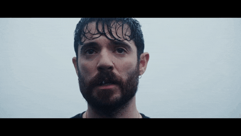 a close up of a man with a beard and wet hair