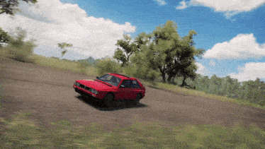 a red car is driving down a dirt road in a video game