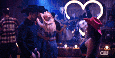 a couple of people dancing in front of a heart shaped light