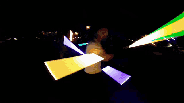 a man in a white shirt is standing in a dark room surrounded by glowing lights