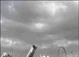 a black and white photo of a plane flying through the clouds