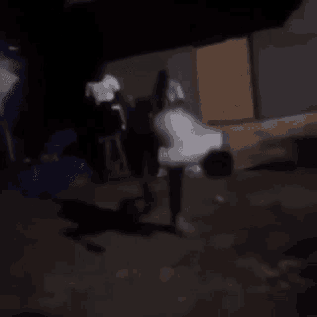 a man is doing a handstand on the ground in front of a group of people at night .