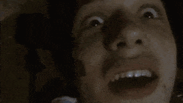 a man is sitting in a dark room with his eyes closed