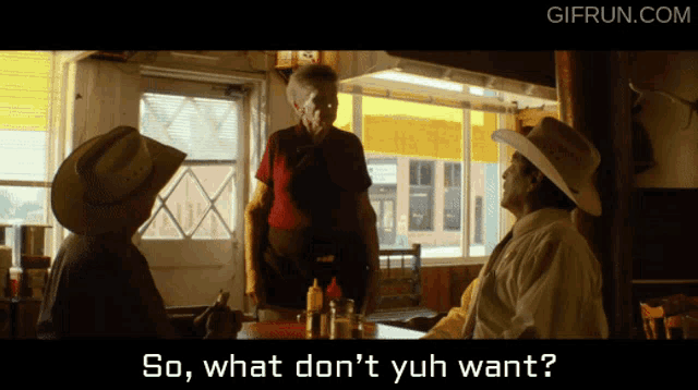 a man in a cowboy hat is talking to another man in a diner