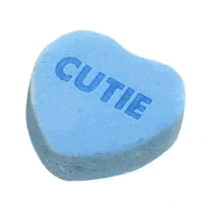 a blue heart shaped candy that says cutie
