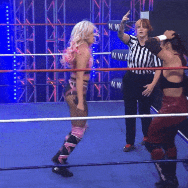 a woman in a wrestling ring with a referee and a ring that says nwa