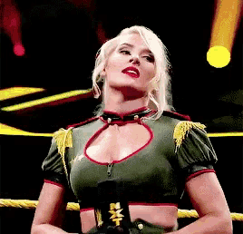 a woman is standing in a ring with a belt that says nxt