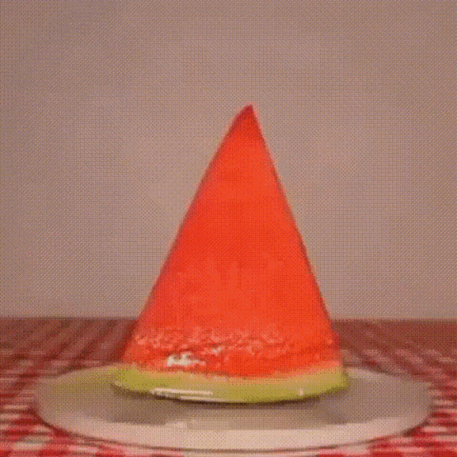 a cat is eating a piece of watermelon on a plate .