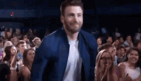 a man in a blue jacket is walking through a crowd of people at a concert .