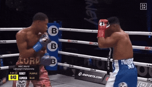 two boxers are fighting in a boxing ring and one of them has the word lord on his shorts