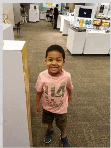 a young boy wearing a pink shirt with the number 04 on it
