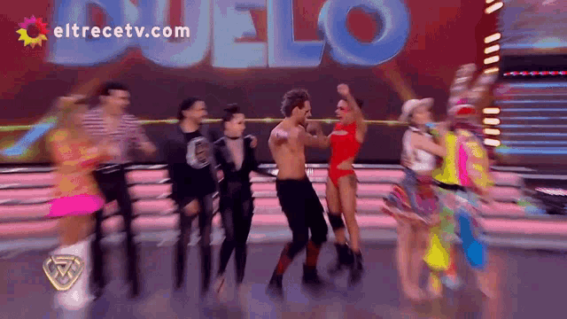 a group of people are dancing in front of a eltrecetv.com logo