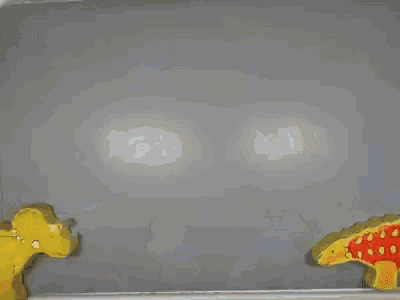 a green dinosaur is surrounded by two yellow dinosaurs