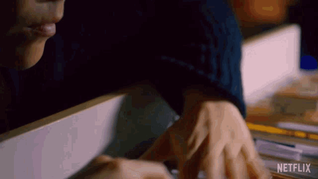 a close up of a person 's hands with the word netflix on the bottom right