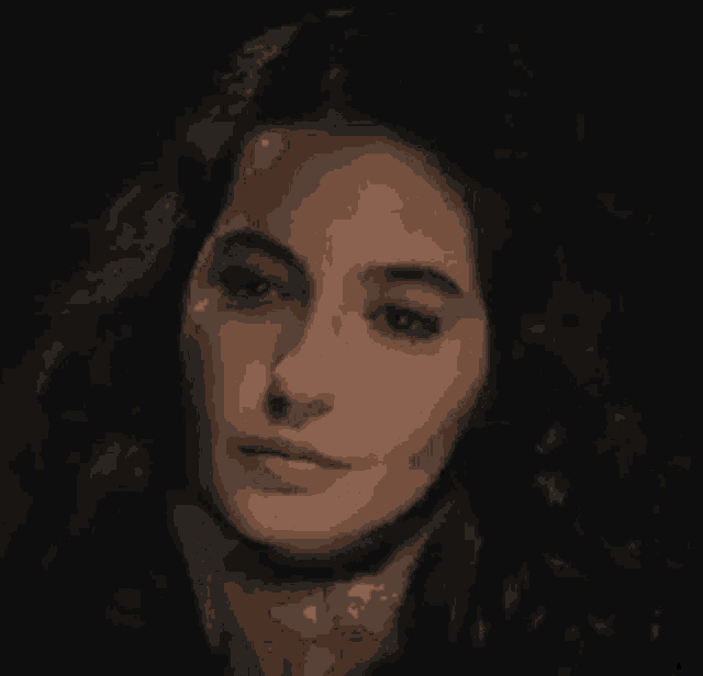 a close up of a woman 's face with her eyes closed and a smile on her face .