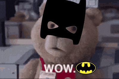 a teddy bear is wearing a batman mask and the word wow is above it