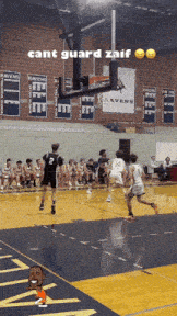 a basketball game is being played in front of a ravens sign
