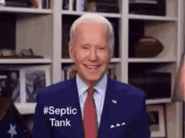 a man in a suit and tie is smiling while wearing a shirt that says `` septic tank '' .
