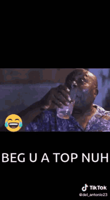 a man is holding a glass in his hand and laughing with the words " beg u a top nuh " below him .