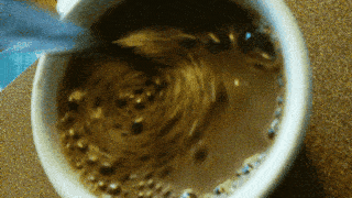 a close up of a cup of coffee with bubbles in it