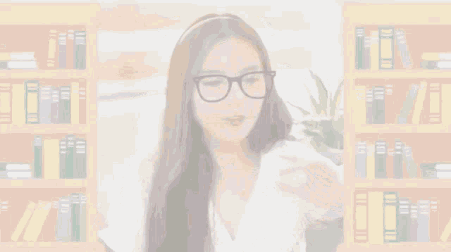 a girl wearing glasses is sitting in front of a bookshelf
