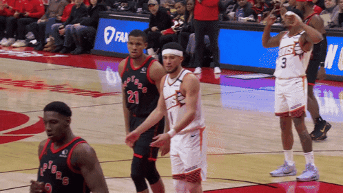 a basketball player with the number 21 on his jersey stands on the court