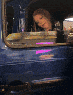 a woman is looking out of a car window with a pink light behind her