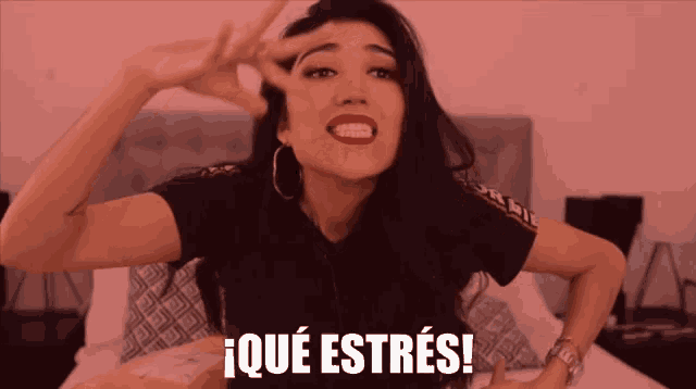 a woman in a black shirt is making a funny face in front of a pink background that says ique estres
