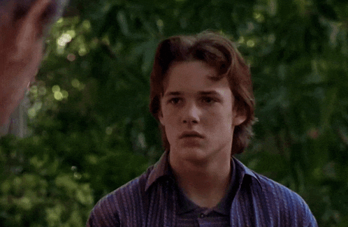 a young man wearing a blue shirt that says ' abercrombie & fitch ' on it looks surprised