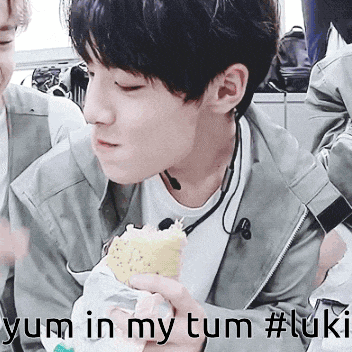 a young man eating a sandwich with the words yum in my tum #luki