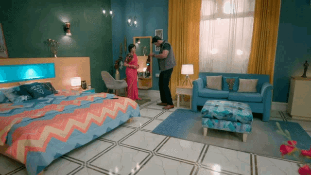 a man standing next to a woman in a bedroom with a couch and a bed