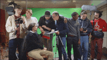 a man in a red atari sweatshirt stands in front of a group of people