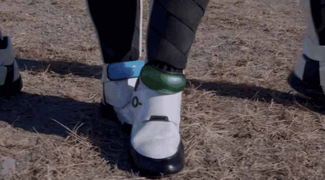 a person wearing a pair of white and black boots with a green o on the side