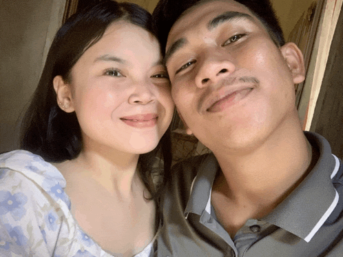 a man and woman are posing for a picture and the woman is smiling