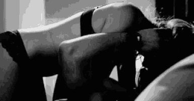 a black and white photo of a woman laying on her stomach .