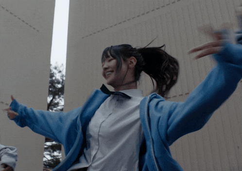 a girl wearing a blue jacket has the number 2 on her shirt