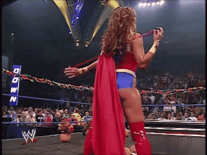 a woman in a wonder woman costume is in a wrestling ring .