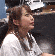 a woman in a white shirt is sitting in a chair looking up at the sky .