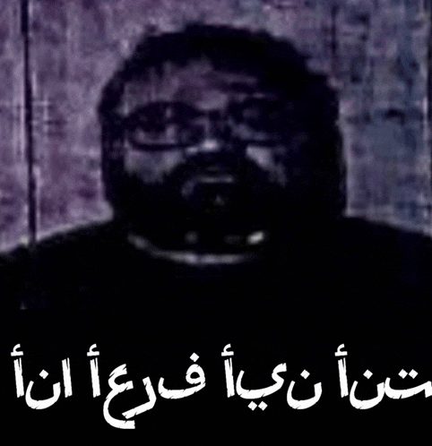 a black and white photo of a man with glasses and the words in arabic