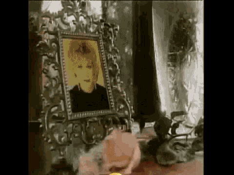 a portrait of a woman in a frame is sitting on a table next to a rose .