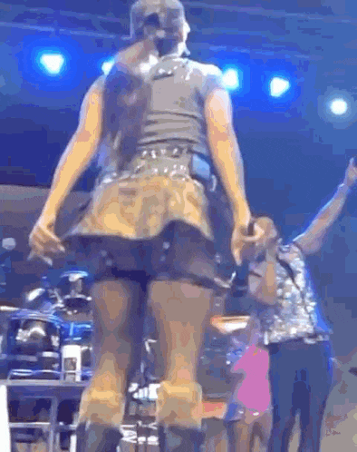 a woman in a short skirt is dancing on a stage