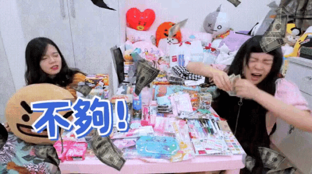 two girls are sitting at a table with chinese writing on the table
