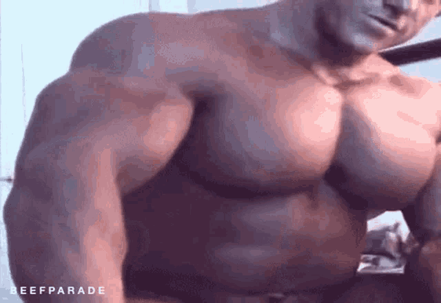 a shirtless man with very large muscles is flexing his muscles .