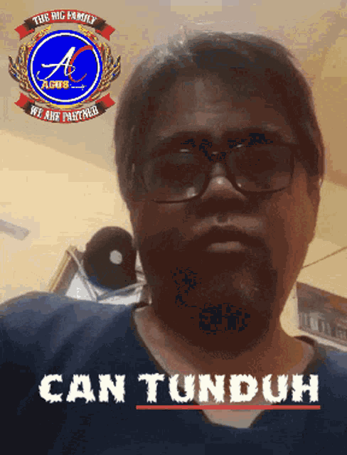 a man wearing glasses and a shirt that says can tunduh on it