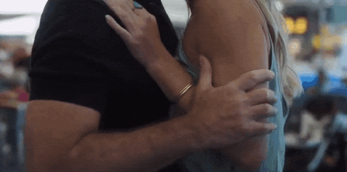 a man and a woman are hugging each other in a restaurant .
