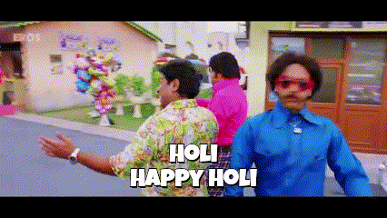 a group of men are standing on a street with the words holi happy holi written on the bottom .