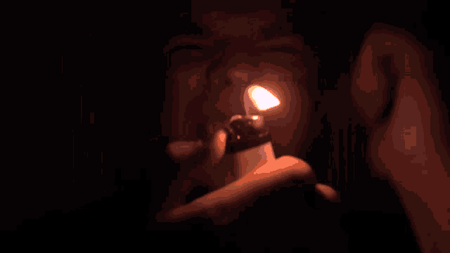 a close up of a person lighting a cigarette with a lighter that has the letter s on it