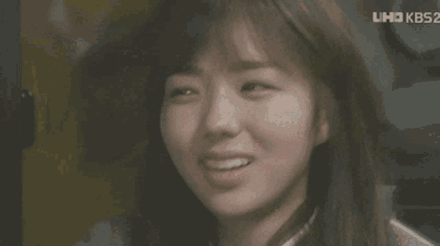a close up of a woman 's face with a kbs2 logo behind her